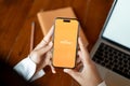 A woman using Payoneer application on her Iphone14 at her desk. Payoneer logo on Iphone14 screen