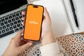 A woman using a Payoneer application on her Iphone14 at her modern office desk