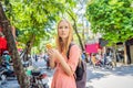 Woman using phone app for taxi ride hailing service or reading travel guide. Girl tourist searching for map directions Royalty Free Stock Photo