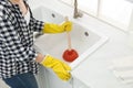 Woman using plunger to unclog sink drain in kitchen, closeup Royalty Free Stock Photo