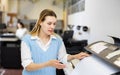 Woman using printer while working in print shop Royalty Free Stock Photo