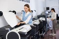 Woman using printer while working in print shop Royalty Free Stock Photo