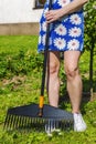 Woman using rake in garden