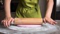 Woman using rolling pin preparing pink fondant for cake decorating Royalty Free Stock Photo