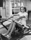 Woman using rowing machine Royalty Free Stock Photo