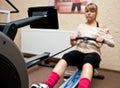 Woman using rowing machine Royalty Free Stock Photo