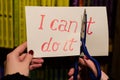 Woman using scissors to remove the word can`t to read I can do it