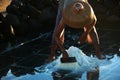 A woman using a scraper to gather sea salt