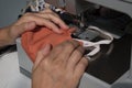 Woman using the sewing machine to making the fabric mask