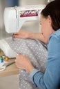 woman using sewing machine to sew clothing Royalty Free Stock Photo