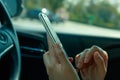 Woman using smart phone on the car