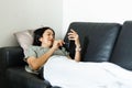 Woman using smart phone while lying on the couch quarantine concept.