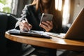 Woman using smart phone for mobile payments online shopping,omni channel,sitting on table Royalty Free Stock Photo