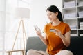 Woman using smart phone for mobile payments online shopping,omni channel,sitting on table in morning light Royalty Free Stock Photo