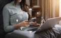 Woman using smart phone for mobile payments online shopping, omni channel, sitting on table, virtual icons graphics interface Royalty Free Stock Photo