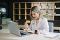 Woman using smart phone for mobile payments online shopping,omni channel,sitting on table,virtual icons graphics interface screen Royalty Free Stock Photo