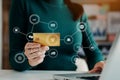 Woman using smart phone for mobile payments online shopping,omni channel,sitting on table,virtual icons graphics interface screen Royalty Free Stock Photo