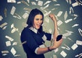 Woman using smart phone under money rain dollars falling down Royalty Free Stock Photo