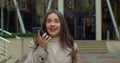 Woman using a smart phone voice recognition function online near Big Modern Office Building, talking to mobile assistant Royalty Free Stock Photo