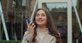 Woman using a smart phone voice recognition function online near Big Modern Office Building, talking to mobile assistant Royalty Free Stock Photo