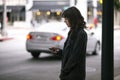Woman Using a Smartphone App Waiting for a Rideshare