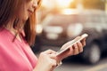Woman using smartphone for the application on car blur background. Royalty Free Stock Photo