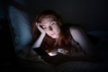 Woman using smartphone in bed late at night in bed Royalty Free Stock Photo