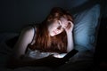 Woman using smartphone in bed late at night in bed Royalty Free Stock Photo