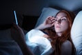 Woman using smartphone in bed late at night in bed Royalty Free Stock Photo