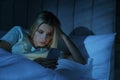 Young woman using smartphone in bed at night. Nomophobia and sleeping disorder problem Royalty Free Stock Photo