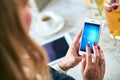 Woman using smartphone computer while preparing breakfast Royalty Free Stock Photo