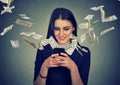 Woman using smartphone with dollar bills flying away from screen Royalty Free Stock Photo