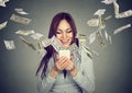 Woman using smartphone with dollar bills flying away from screen Royalty Free Stock Photo