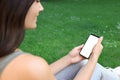 Woman using smartphone on green grass outdoors, closeup Royalty Free Stock Photo