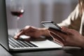 Woman using smartphone and laptop at table indoors. Loneliness concept Royalty Free Stock Photo