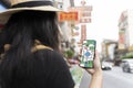 A woman using a smartphone navigation app on the road during the day. All on mobile screens are designed