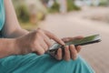 Woman using smartphone outdoors in the park, close up of female hands with mobile phone Royalty Free Stock Photo