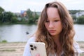 woman using smartphone at the park smiling. Child Playing on Smartphone in Park, Kid Browsing Internet on Smart Phone Royalty Free Stock Photo