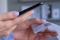 Woman using smartphone and scanning qr code on cash shop receipt paper - closeup