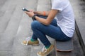 Woman using smartphone sit on skateboard