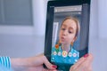 Woman using Snapchat multimedia messaging app with face mask on tablet