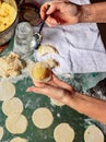 Woman using a spoon sculpts dumplings with potatoes in Ukrainian national cuisine