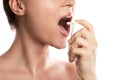 Woman is using spray with analgesic for sore throat relief