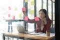 A woman using a sticky note and analysis data report during writing make note some data on notepad, Business financial Royalty Free Stock Photo