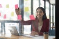 A woman using a sticky note and analysis data report during writing make note some data on notepad, Business financial Royalty Free Stock Photo