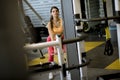 Woman using straight bar cable to pull up weights to exercise biceps in the gym Royalty Free Stock Photo