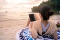 Woman is using a tablet on beach Royalty Free Stock Photo