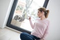 Woman using tablet computer with cats on snow in background