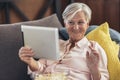 Woman using tablet computer while relaxing on sofa at home Royalty Free Stock Photo
