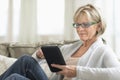 Woman Using Tablet Computer On Sofa Royalty Free Stock Photo